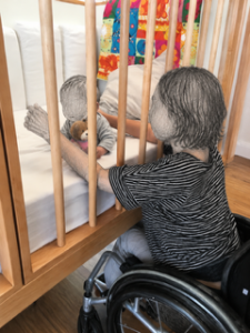 Höhenverstellbarer Laufstall mit Mutter im Rollstuhl und Kind